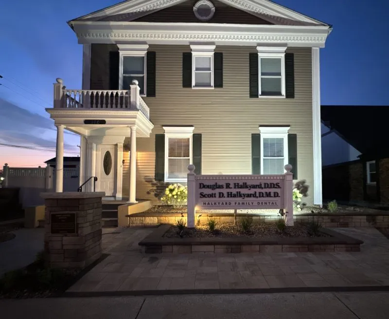Halkyard Family Dental Office Building at night with the sign light on.